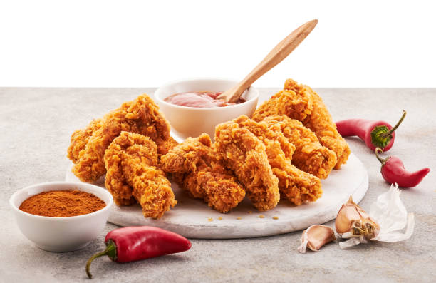 Spicy chicken wings breaded with spices and ketchup on the table. stock photo