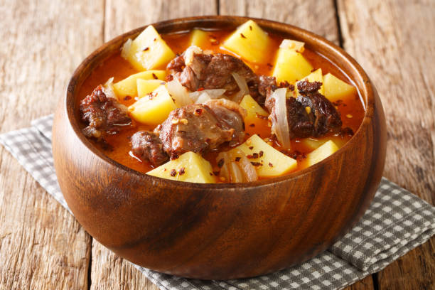 Spicy lamb stew and potatoes in pepper sauce close-up in a bowl. horizontal stock photo