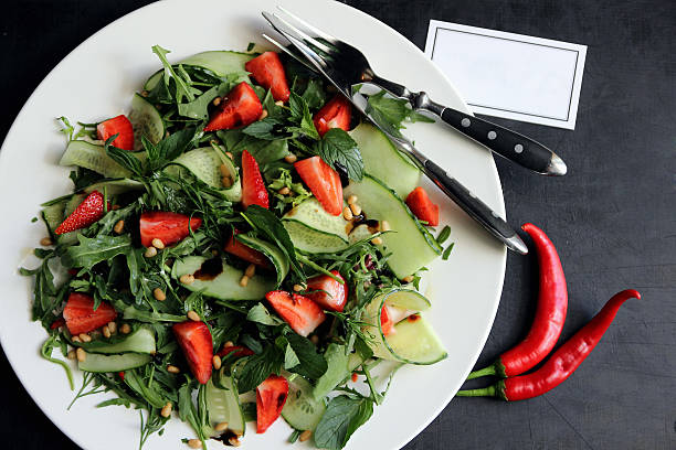 Spicy salad of strawberries and cucumber seasoned with herbs and sauce.. stock photo