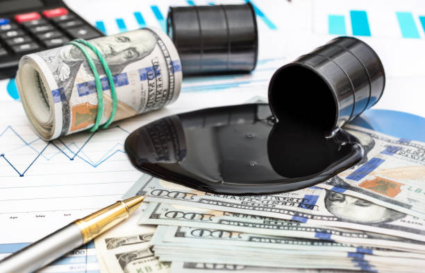 Spilled crude oil with money and calculator on financial graphs. Spilled crude oil with money and calculator on financial graphs. oil market  stock pictures, royalty-free photos & images