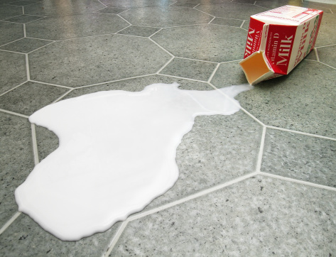 Carton of milk spilled on the floor.