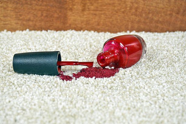 spilled red nail polish on carpet Close up of bright red nail polish on light colored carpet nail polish stock pictures, royalty-free photos & images