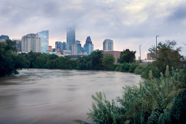 Spilled river and water flowing with great speed against the background of the city. Effects Tropical Storm Imelda. Houston, Texas, US stock photo