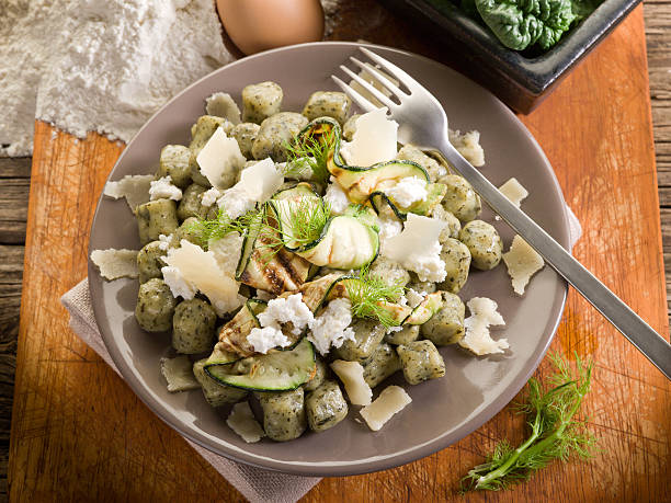 spinach gnocchi with ricotta, zucchinis and parmesan flakes stock photo