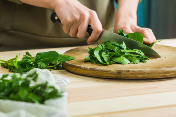 Spinach leaves are chopped on a wooden kitchen board. stock photo