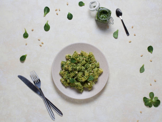Spinach pasta with cutlery on a white table. stock photo
