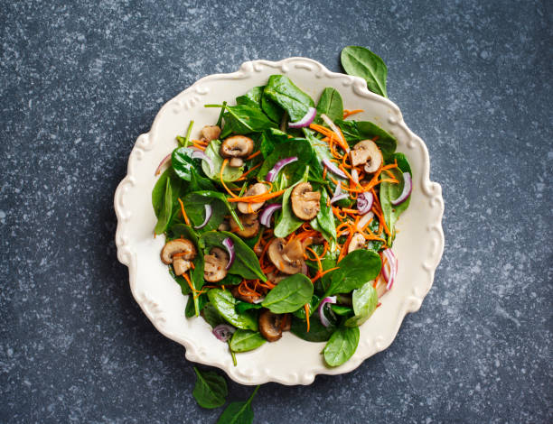 Spinach salad with sherried mushrooms and carrots stock photo