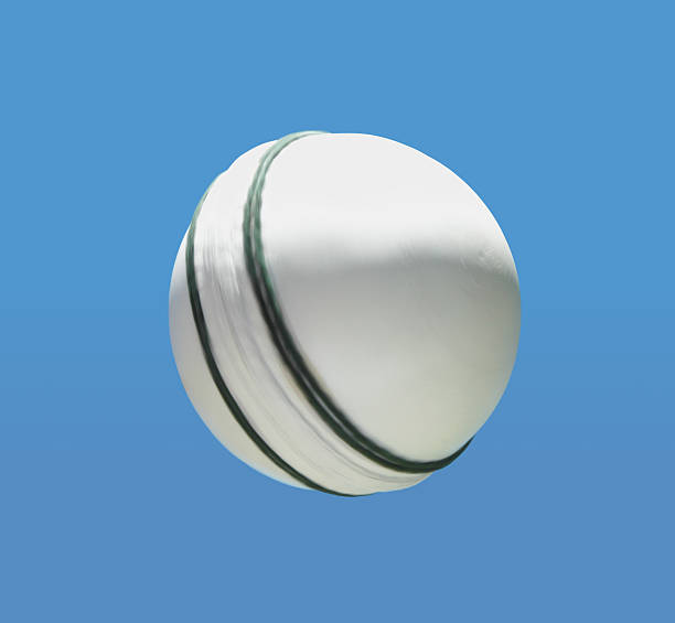 Spinning white cricket ball stock photo