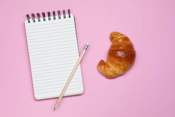 spiral notebook and croissant - de franse pennen stockfoto's en -beelden