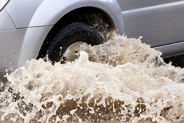 Splash by a car as it goes through flood water stock photo