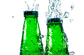 Splash on green soda bottles on white