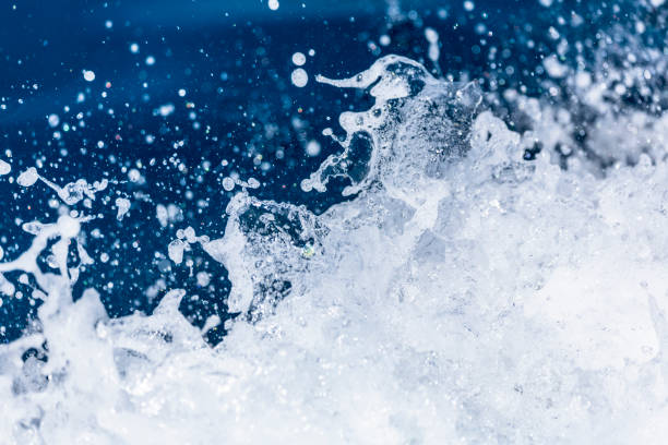Photo of Splashing sea water with foam, bubbles and defocused lights. Close up detail of the wake of large cruise ship.