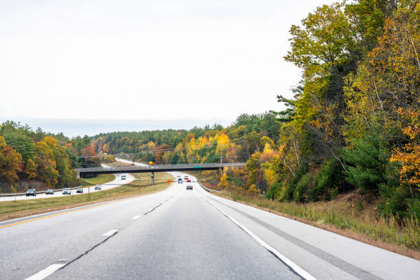Split highway road with a bridge and autumn trees on the sides in New Hampshire stock photo