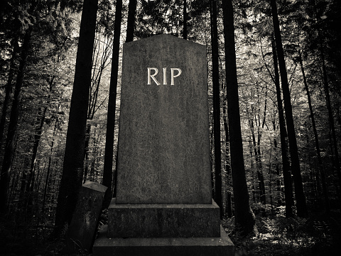 Spooky RIP Gravestone In A Dark Forest Setting