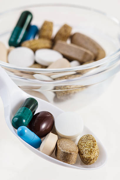 Spoon of various colorful pills stock photo