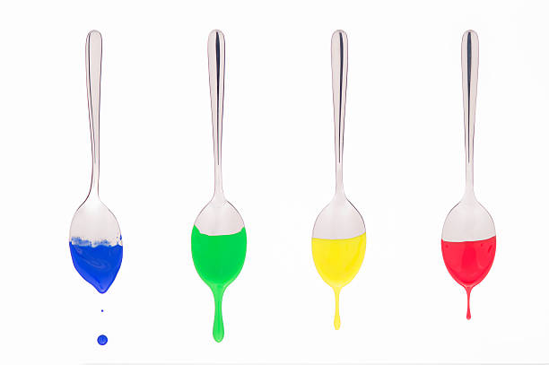 spoons suspended bathed in colored paint stock photo