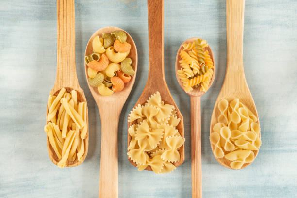 Spoons with assorted pasta types Colorful and stylist composition uncooked pasta stock pictures, royalty-free photos & images