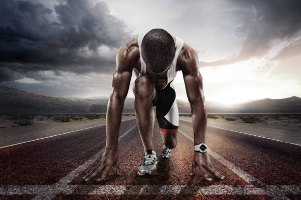 Sport backgrounds. Sprinter on the start line of the track befor the dramatic sky. Sport. Runner. athleticism stock pictures, royalty-free photos & images