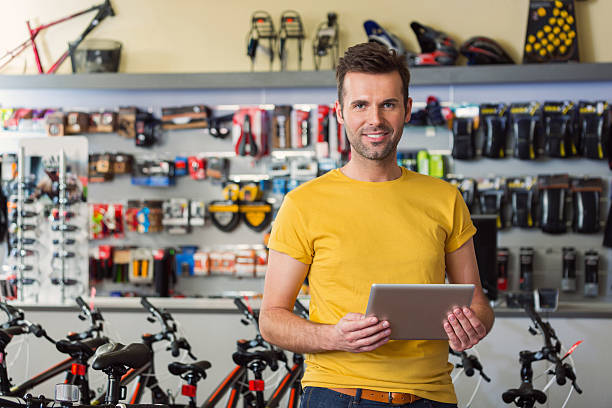 sport store manager with digital tablet - fietsenwinkek stockfoto's en -beelden