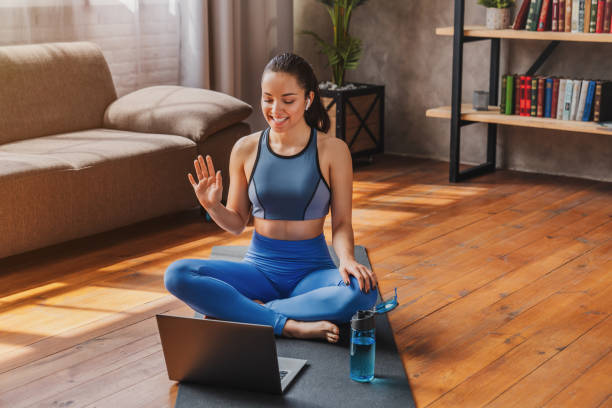 Sport training online. Young woman sits on the floor and talking with coach by laptop  personal trainer stock pictures, royalty-free photos & images