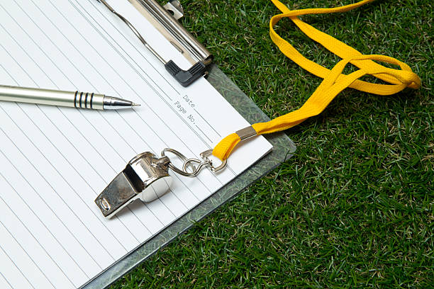 Sport whistle with pen and clipboard on grass Clipboard with metal sport whistle, pen and paper sheet on grass サッカー グッズ stock pictures, royalty-free photos & images