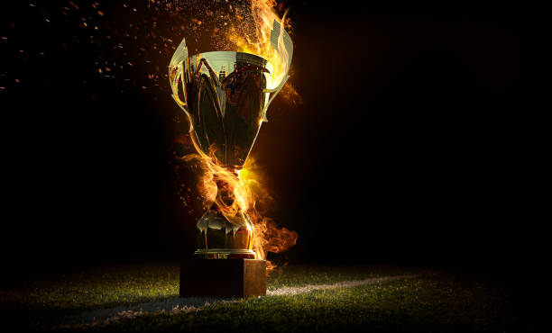Sports background. Burning trophy goblet. Winner in a competition. Fire and energy. Football field with golden goblet. stock photo