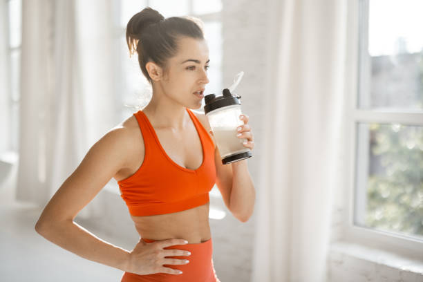 Sports woman with protein shaker at gym stock photo
