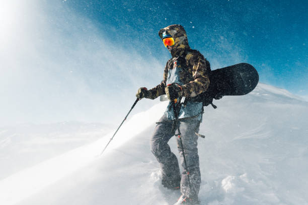sportsman go with snowboard equipment in the snowstorm stock photo