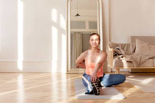 Sportswoman stretching body during training at home stock photo