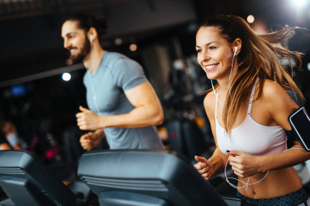 orang-orang sporty berlari di treadmill di klub kesehatan - treadmill potret stok, foto, & gambar bebas royalti