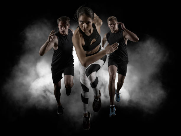 Sporty young woman and men running stock photo