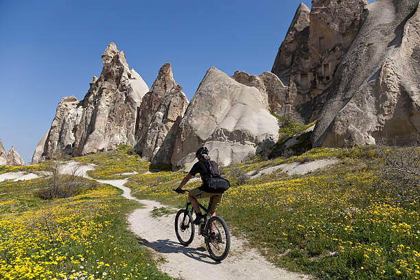 Spring  biking in Cappadocia, Turkey Mountainbiking in springtime is an exciting experience. Lots of flowers are growing out and you can ride the bike between fairy chimneys of this landscape which has been listed to the UNESCO World Heritage list in 1985. rock hoodoo stock pictures, royalty-free photos & images