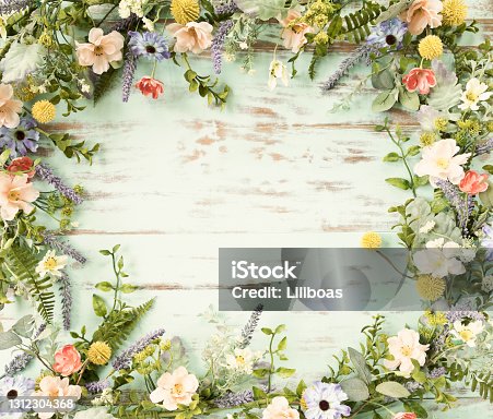 istock Spring flower wreath garland frame on an old rustic blue wood background 1312304368
