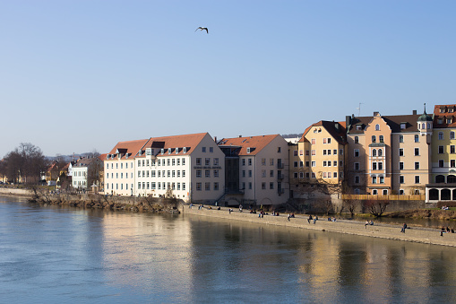 Regensburg, Germany - February, 25th 2021: People enjoying spring by the river Danube in Regensburg city center