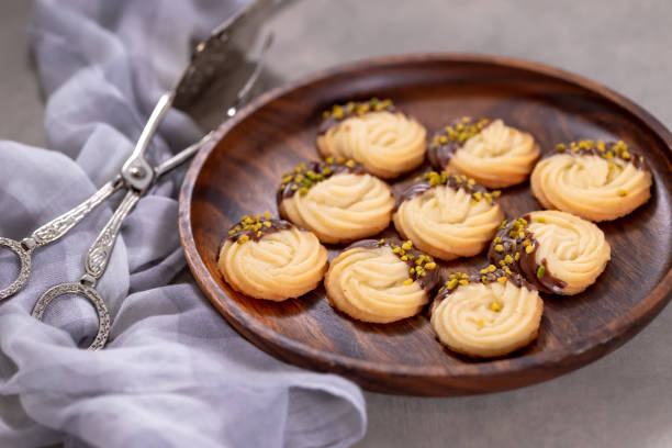 Spritz butter cookies dipped in chocolate on plate stock photo