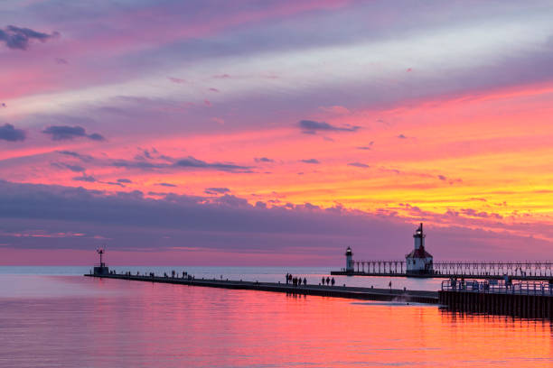 St. Joseph Afterglow The setting sun paints the sky above Lake Michigan in glorious color and silhouettes the lighthouses and sightseers on the North and South Pier at St. Joseph, Michigan. pierhead liverpool stock pictures, royalty-free photos & images