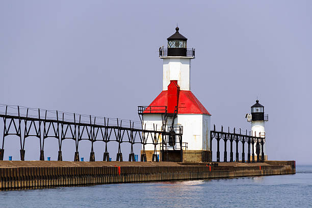 St. Joseph, Michigan North Pier Lights Lighthouses on the breakwater at St. Joseph, Michigan extend into Lake Michigan along with elevated catwalks that were used to approach the lights in inclement weather in days gone by. north pier stock pictures, royalty-free photos & images