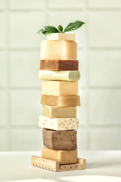 Stack of assorted natural soap bars on white bathroom countertop stock photo