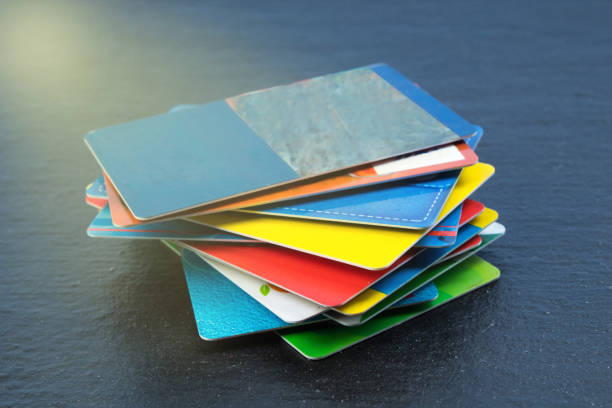 pila de tarjetas bancarias sobre un fondo negro. - pile of credit cards fotografías e imágenes de stock