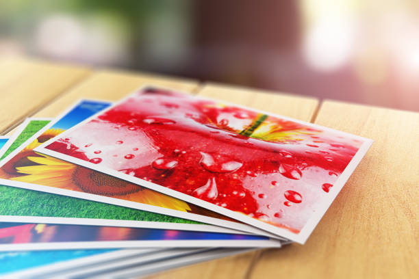 Stack of color photo pictures on wooden table outdoors Creative abstract 3D render illustration of the macro view of stack of color photo pictures on wooden table outdoors with selective focus bokeh blur effect heap photos stock pictures, royalty-free photos & images