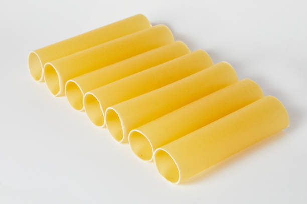 stack of dried cannelloni pasta Close up of a stack of dried cannelloni pasta, a tubular pasta that is usually stuffed with meat or vegetables, on a white background. Italian cannelloni pasta tubes uncooked pasta stock pictures, royalty-free photos & images