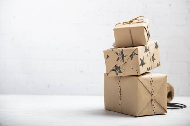 Stack of handcraft gift boxes on white brick background stock photo