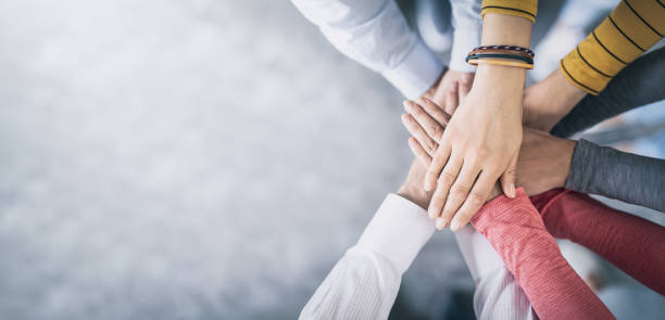 Stack of hands. Unity and teamwork concept. Close up top view of young business people putting their hands together. Stack of hands. Unity and teamwork concept. panoramic photos stock pictures, royalty-free photos & images