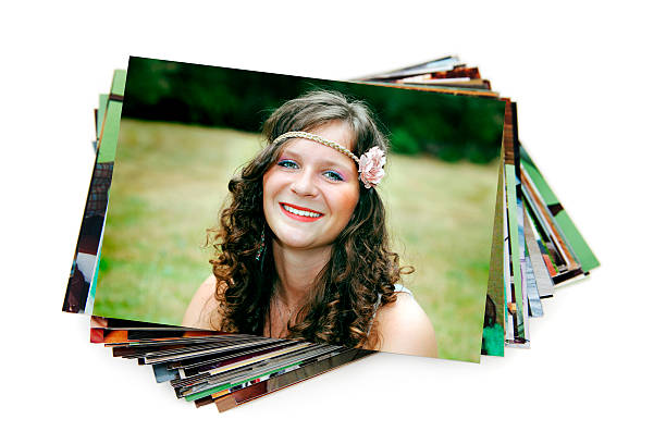 Stack of holiday photographs on white stack of paperphotographs on white background with a beauty smiling dark hair teenager on the first image heap photos stock pictures, royalty-free photos & images