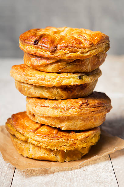 Stack of homemade meat pies on a rustic table A stack of fresh meat pies on a rustic table. meat pie stock pictures, royalty-free photos & images