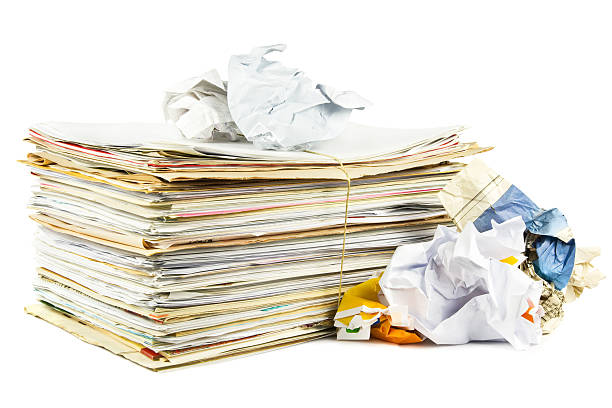 A stack of paper beside crumpled papers stock photo