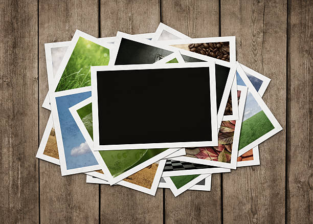 Stack of photos at wooden background Stack of old photographs at grunge wooden background with clipping path for the blank one group of objects photos stock pictures, royalty-free photos & images