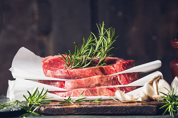 Stack of  raw steaks with rosemary stock photo