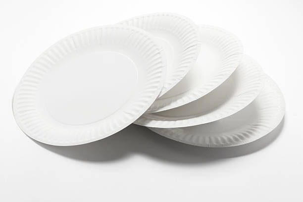Stack of white paper plates on white surface stock photo