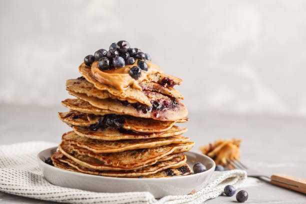 Stack vegan blueberry pancakes with peanut butter and syrup. stock photo